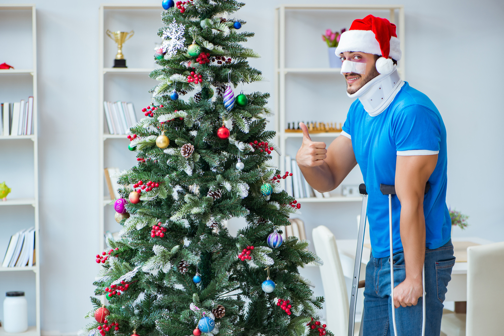 Injured man celebrating Christmas with a Christmas tree behind him.