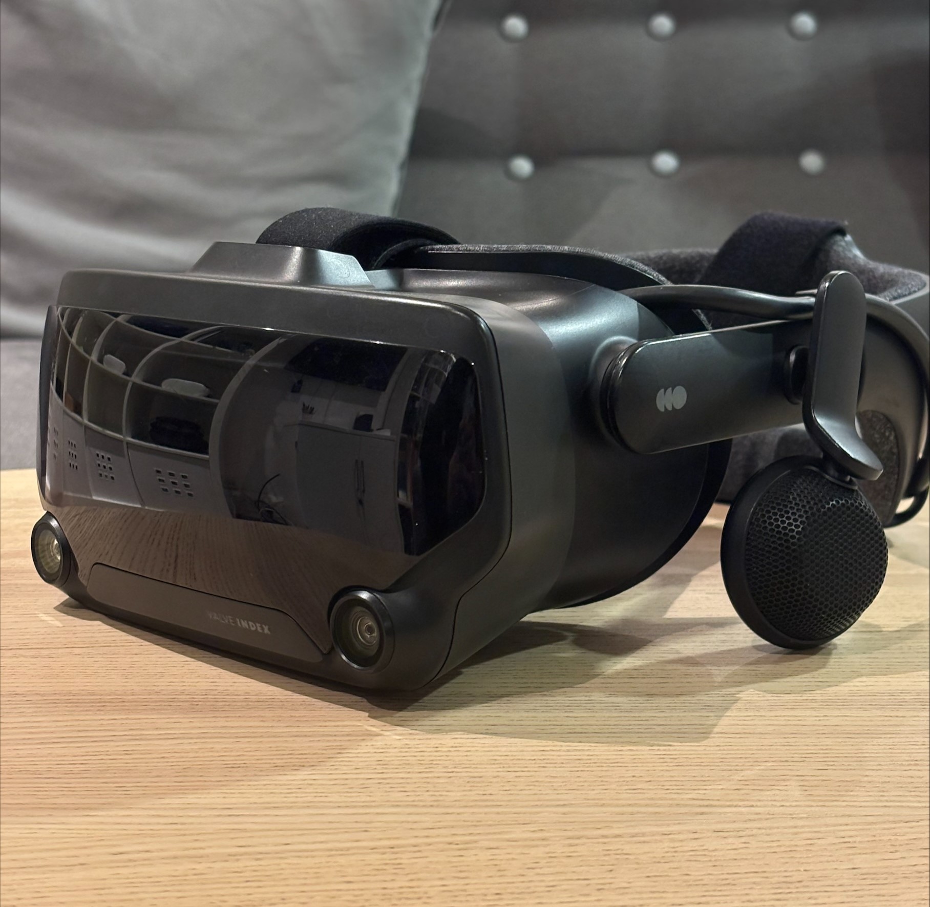 Photo of a valve index VR headset on a coffee table beside a sofa